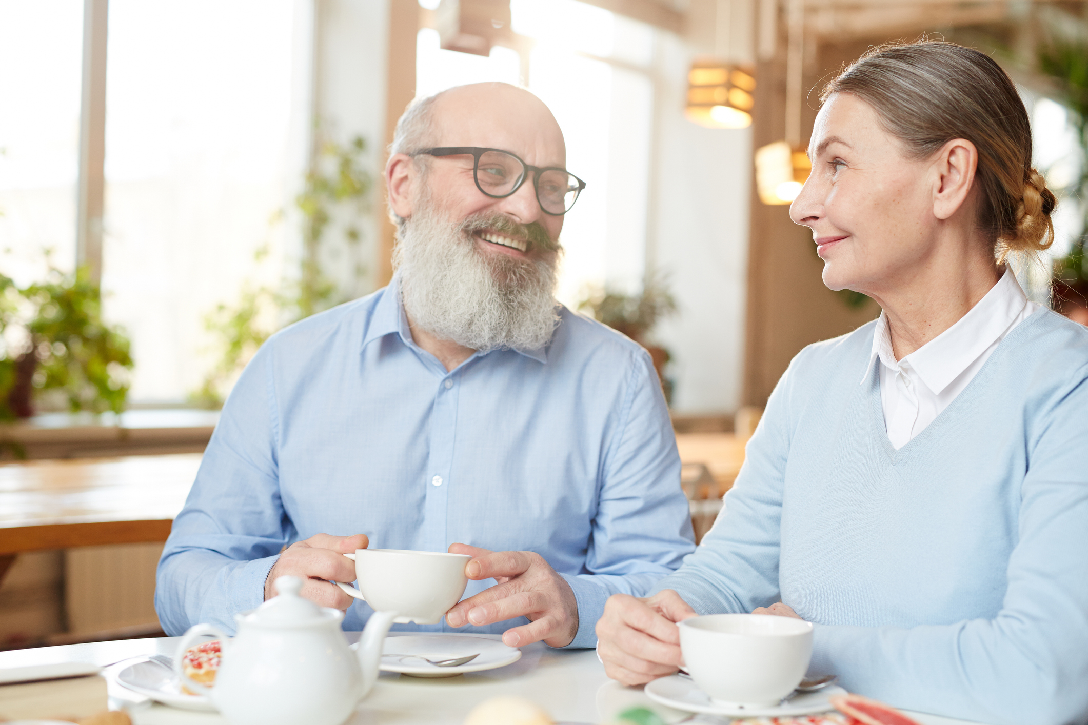 Man en vrouw drinken koffie en voeren keukentafelgesprek