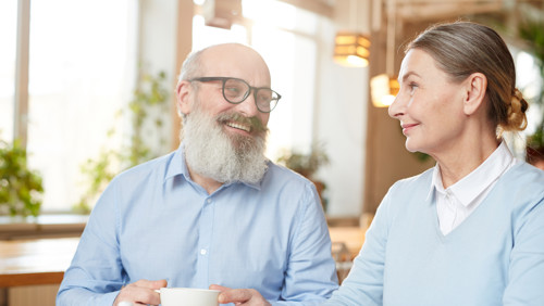 Man en vrouw drinken koffie en voeren keukentafelgesprek Man en vrouw drinken koffie en voeren keukentafelgesprek