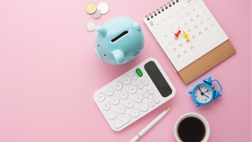 Een collectie van kantoorspullen en een spaarpot Een collectie van kantoorspullen en een spaarpot