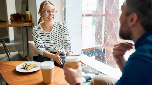collega's zitten aan tafel koffie te drinken collega's zitten aan tafel koffie te drinken