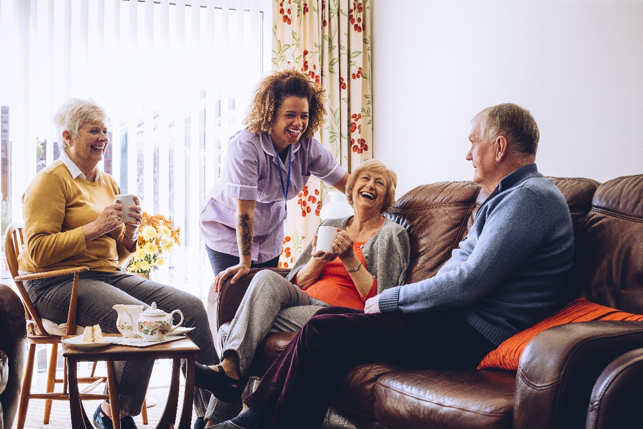 Vrouwen en man lachen in woonkamer