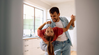 Jong stel danst in hun nieuwe keuken (Getty) Jong stel danst in hun nieuwe keuken (Getty)