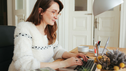 Vrouw werkt thuis achter haar laptop Vrouw werkt thuis achter haar laptop