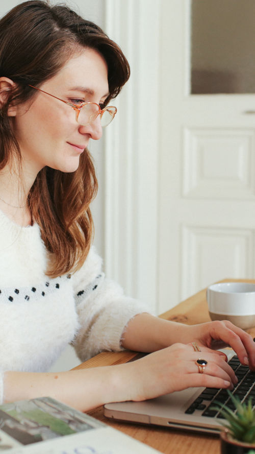 Vrouw werkt thuis achter haar laptop Vrouw werkt thuis achter haar laptop