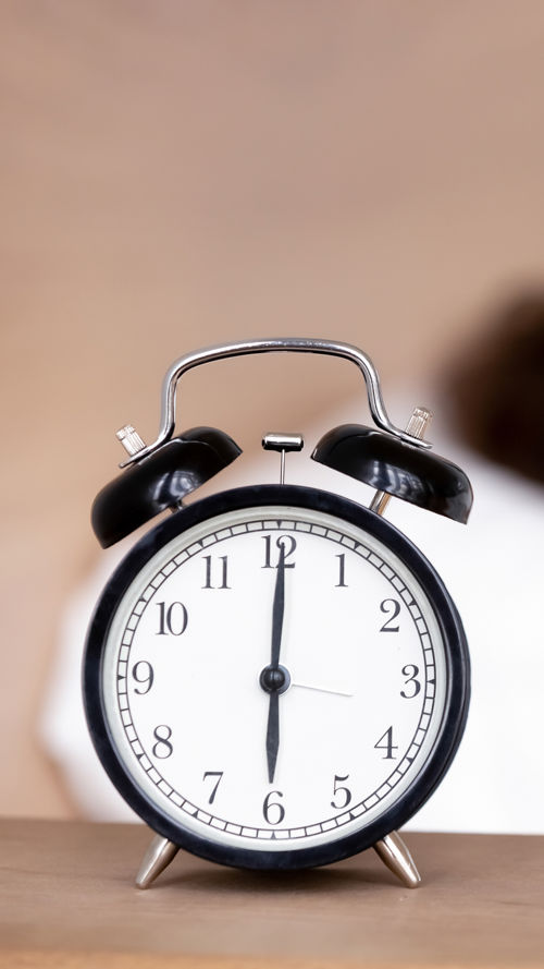 Wekker met slapende vrouw op achtergrond Wekker met slapende vrouw op achtergrond