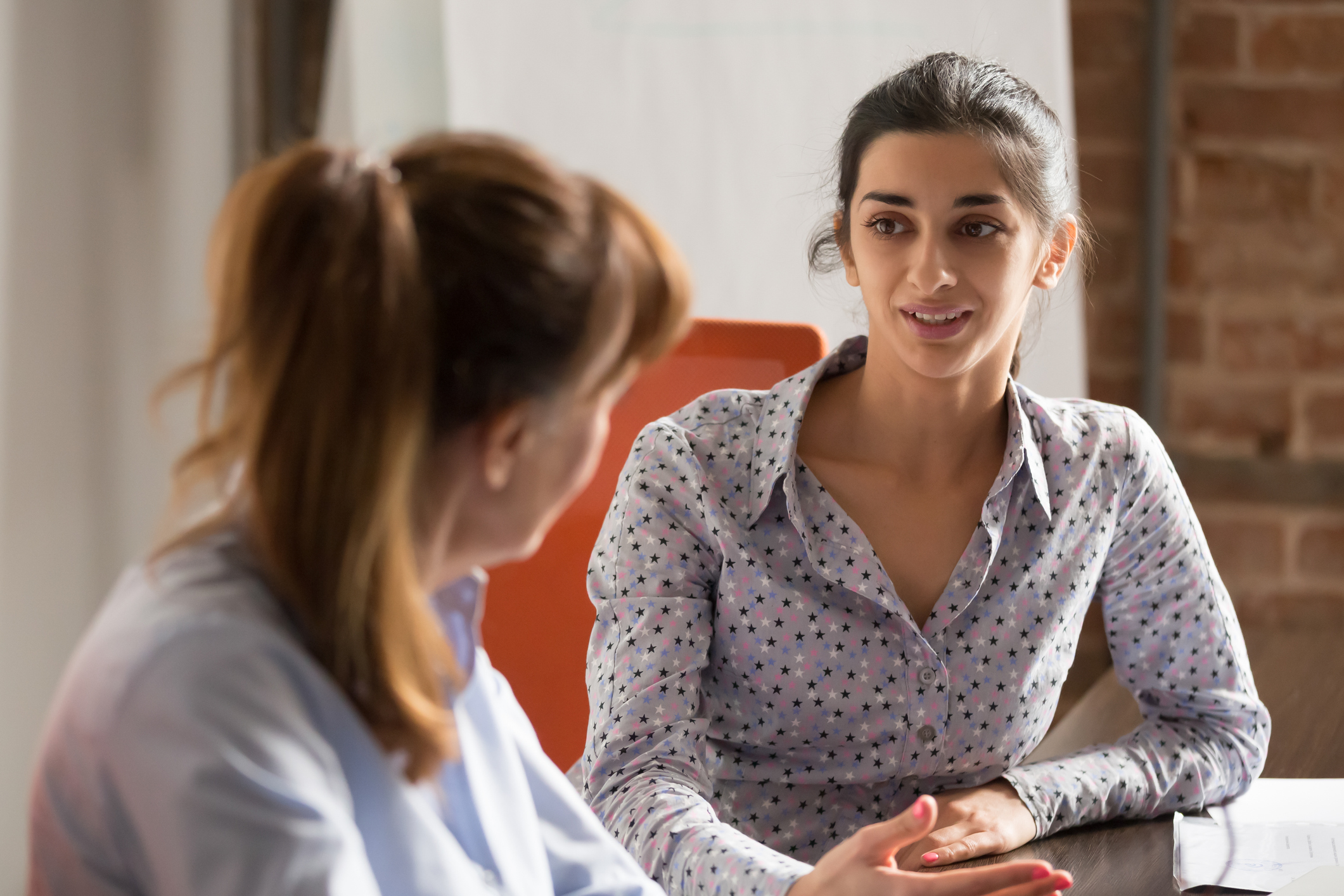 Twee vrouwen aan tafel in gesprek