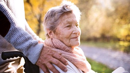 Man duwt vrouw in rolstoel Man duwt vrouw in rolstoel