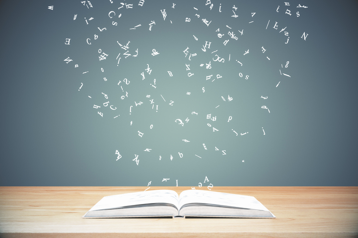 Boek op tafel met zwevende letters erboven