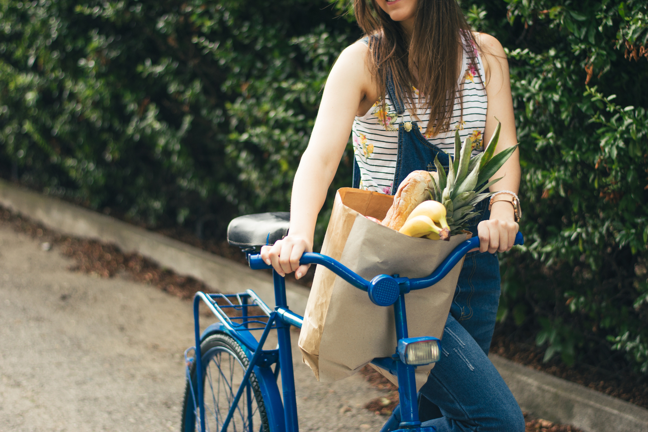 Vrouw met fiets en boodschappen 
