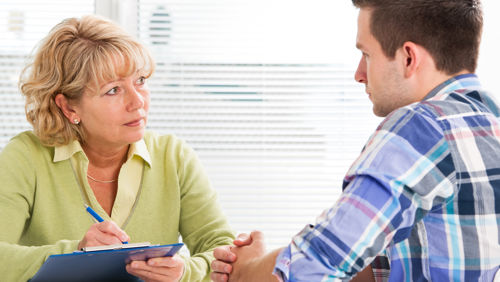 Man en vrouw in gesprek op werk Man en vrouw in gesprek op werk